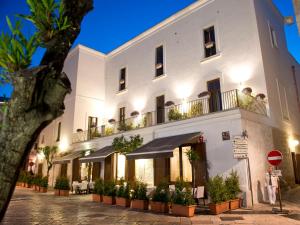 a white building with plants on the balconies at Palazzo Indelli in Monopoli