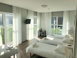 a room with three beds and a table and windows at National Golf Resort in Klaipėda +71 photos