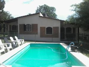a swimming pool with a hose attached to a house at La Casa de Ana in Bialet Massé