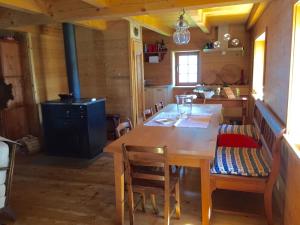eine Küche mit einem Holztisch, Stühlen und einem Herd in der Unterkunft Chalet Charm in Molare