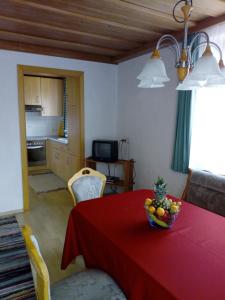 a dining room with a red table with a bowl of fruit on it at Berningerhof in St. Wolfgang