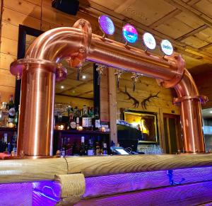 um bar com uma tubagem de cobre no balcão em Guest House du Grand Paradis - On Piste em Champéry