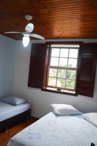 a bedroom with two beds and a window at Pousada Simone in Ouro Preto