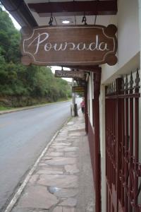 a sign for a restaurant on the side of a road at Pousada Simone in Ouro Preto