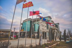 Un bâtiment avec de nombreux drapeaux devant lui dans l'établissement Hotel New Star, à Skopje