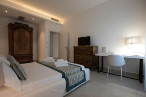 a bedroom with a bed and a desk and a table at Castello Tafuri in Portopalo