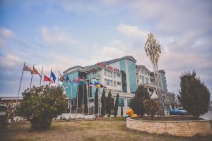 un grand bâtiment avec drapeaux devant lui dans l'établissement Hotel New Star, à Skopje