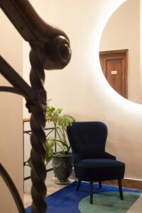 a room with a blue chair and a mirror at Relais Stibbert Florence in Florence