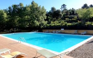 a large swimming pool with chairs and a table at La Colline des Ocres Village de vacances in Apt