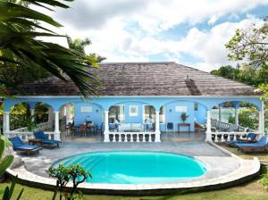 a swimming pool in front of a house at Jamaica Inn in Ocho Rios