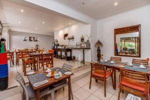 a dining room with wooden tables and chairs at Sitatunga Guest Lodge - Sandton - Airport Shuttle - Solar & Borehole in Johannesburg
