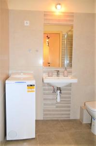 a bathroom with a sink and a mirror and a toilet at Downtown Apartments DeLuxe in Győr
