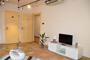 sala de estar con TV y mesa en Downtown Apartments DeLuxe en Győr