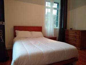 - une chambre avec un lit blanc et une fenêtre dans l'établissement Quinta do Serrado II, à Ribeira da Janela