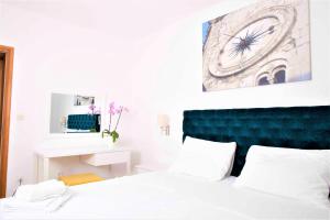 1 dormitorio con 1 cama y reloj en la pared en Villa Bilic, en Rogoznica