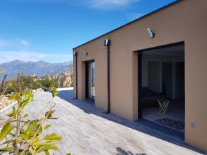 a house with a large glass door on a patio at Résidence Le Bella Vista in Piana +18 photos