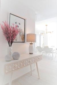 una sala de estar con una mesa con una lámpara y flores en City Valencia Beach 360 en Valencia