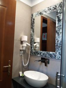 a bathroom with a sink and a mirror at Pansion Irini in Ouranoupoli