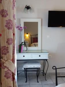 tocador blanco con espejo en la habitación en Pansion Irini, en Ouranoupoli