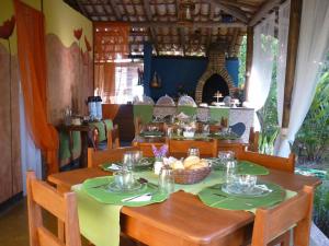 a dining room with a table and chairs with food on it at Flat Bang-Lu in Barra Grande