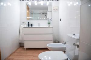a white bathroom with a toilet and a sink at Apartamento CA L'ANTON con Parking in Rialp +40 photos