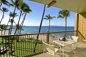 balcón con mesa, sillas y vistas al océano en Mana Kai Maui en Wailea