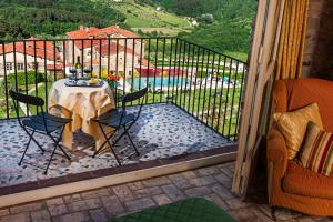 d'un balcon avec une table, des chaises et une piscine. dans l'établissement Castello Di Mammoli, à Lucques