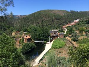 a small village on a hill with a river at Casas do Rio in Pampilhosa da Serra