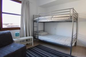 sypialnia z 2 łóżkami piętrowymi i kanapą w obiekcie Plaza del Charco - Puerto Viejo w Puerto de la Cruz