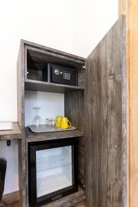 a kitchen with a microwave on a wooden shelf at Apinelo Tower Rooms in Split