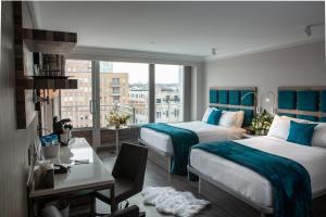 Habitación de hotel con 2 camas y ventana en Hotel Le Bleu, en Brooklyn