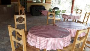 two tables and chairs with red and white table cloth at Hotel Belair KAFLAND in Mimpassem