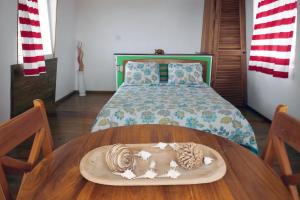 a bedroom with a bed and a wooden table with a plate on it at Faro del Colibri in Bocas del Toro