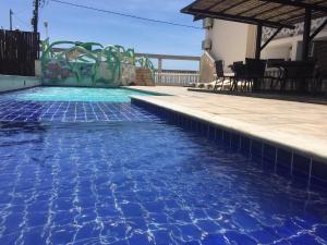 una piscina con agua azul en una casa en Eden Praia Hotel, en Porto Seguro