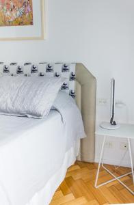 1 dormitorio con cama blanca y mesa blanca en Optimus BA | Arenales en Buenos Aires
