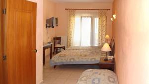 1 dormitorio con cama, escritorio y ventana en Gialaki, en Pyrgadikia