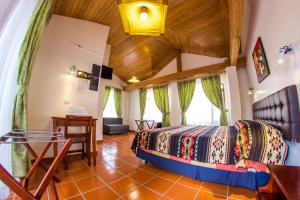a bedroom with a bed and a table in a room at Hostal Riviera Sucre in Otavalo
