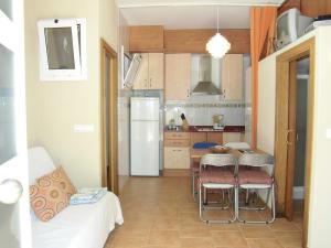 a kitchen with a refrigerator and a table and chairs at Majestic in Lloret de Mar