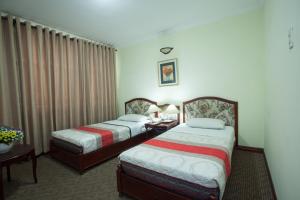 Habitación de hotel con 2 camas y mesa en Hoang Ha Hotel, en Ho Chi Minh