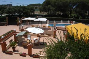 a patio with umbrellas and a swimming pool at Riotinto Victorian House in Minas de Ríotinto