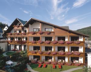 a large building with flowers on the balconies at Wellnesshotel Bürgerstuben in Willingen