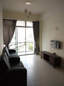 a living room with two couches and a large window at Cameron Cactus Apartment @ Pangsapuri Kaktus in Brinchang