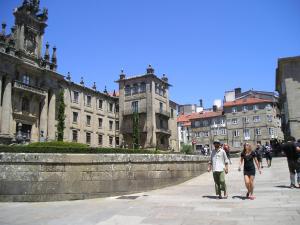 mężczyzna i kobieta idący ulicą miasta w obiekcie Apartamentos Casa de La Inmaculada w Santiago de Compostela
