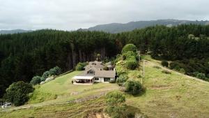 an aerial view of a house on a grassy hill at Waiwurrie Coastal Farm Lodge in Mahinepua
