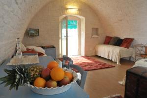 una sala de estar con un bol de fruta en una mesa en Palazzo Agrusti - Residenza D'Epoca, en Alberobello