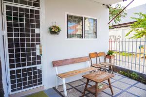 OYO 433 Nelvi Guest House Syariah في بادانج: مقعد على الشرفة الأمامية للمنزل