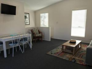 a living room with a table and a couch at The Lake Guesthouse in Budgewoi