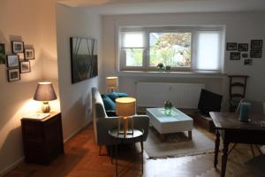 a living room with a couch and a table at Schönes Appartement mit Gartenblick in Baden-Baden