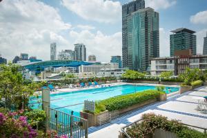 a swimming pool with a city skyline in the background at Trinity Silom Hotel in Bangkok