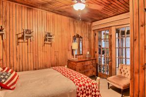 - une chambre avec des murs en bois, un lit et une chaise dans l'établissement Lake Escape, à Charlevoix